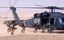 photo of U.S. soldiers rapidly boarding a military helicopter with their fighting equipment