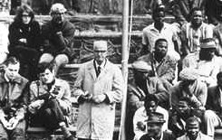 photo of people in the audience at an Apartheid era sporting event in South Africa--"whites" and "blacks" are seated in different sections that are separated from each other by a rope