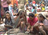 Photo of 4 Papua New Guinea women selling and talking in a market place