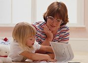 photo of a North American mother playing with her preschool age daughter on the floor